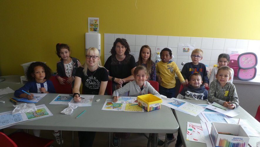 Un groupe d’enfants autour de Mélanie et Déborah lors de l’atelier "La grande lessive".