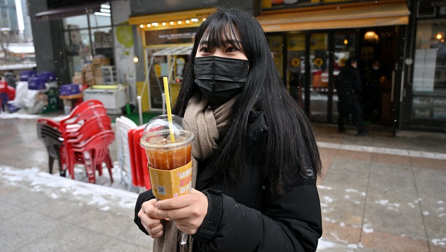 Emmitouflée dans une doudoune jusqu'aux chevilles, Lee Ju-eun, employée de bureau, grelotte sur un trottoir du centre de Séoul en serrant son café glacé pendant la vague de froid polaire.