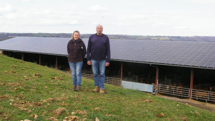 Fabienne et Éric devant un des hangars couvert de panneaux photovoltaïque.