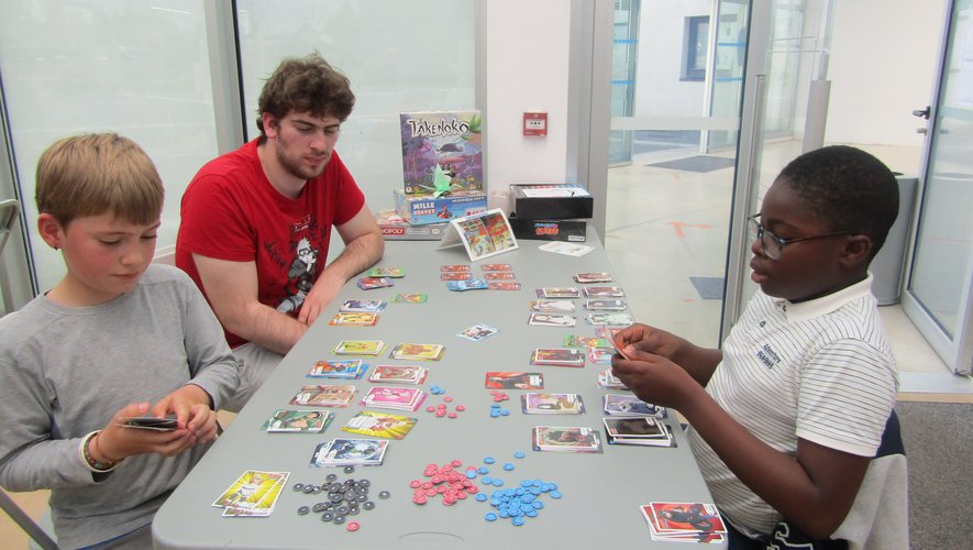 Ezekiel (à droite) explique les règles du jeu à deux nouveaux joueurs.