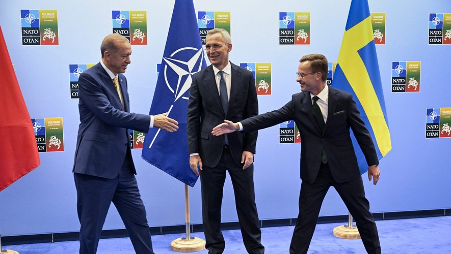 Recep Tayyip Erdogan et Ulf Kristersson s'apprêtent à se serrer la main, sous le regard de Jens Stoltenberg.
