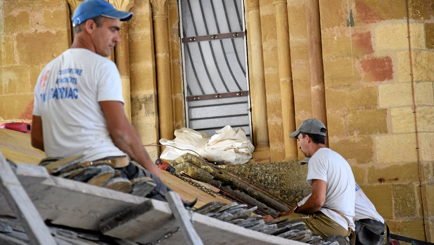 Les couvreurs travaillent à la réfection de la toiture de l’abbatiale sous l’œil du maire Bernard Lefebvre et des frères prémontrés.