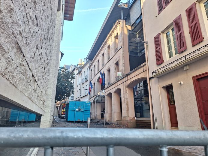 La rue est bloquée par des barrières, mais une partie des dégâts est déjà visible.