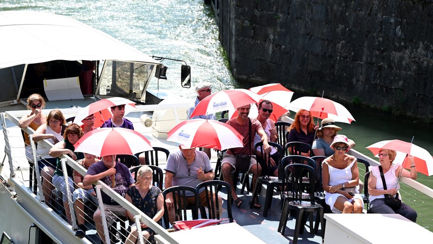 Des touristes en balade sur le canal du Midi à Toulouse ont sorti les parapluies pour se protéger du soleil.