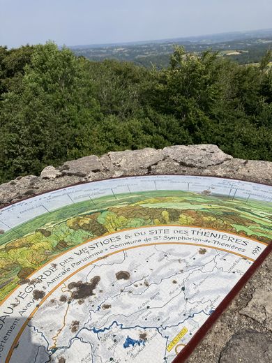 Sur une butte granitique, là où se trouvent les ruines du château de Thénières, une table d’orientation permet de découvrir les monts du Cantal.