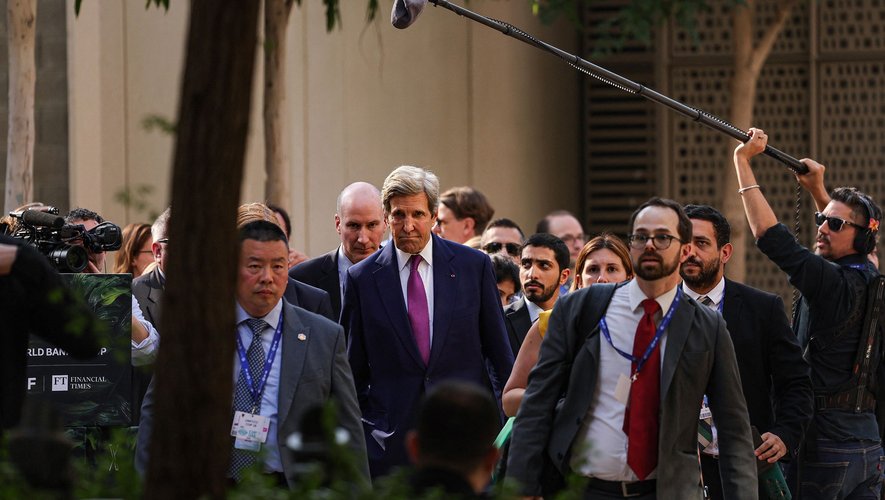L'envoyé spécial du président américain pour le climat, John Kerry (C), arrive pour visiter le pavillon de l'Ukraine lors du sommet des Nations unies sur le climat à Dubaï.