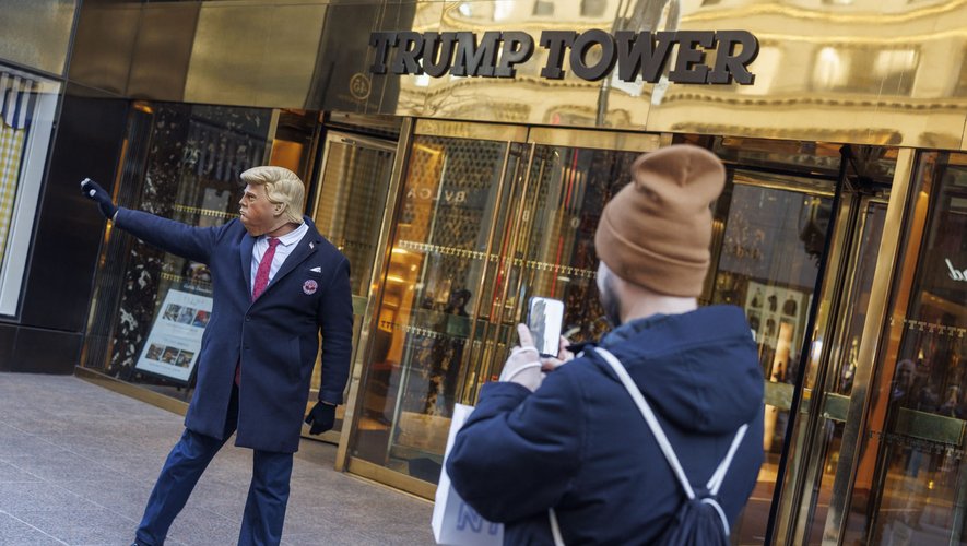Durant le jugement de Donald Trump, une personne portant un masque fait le show devant la Trump Tower, symbole de son empire immobilier.